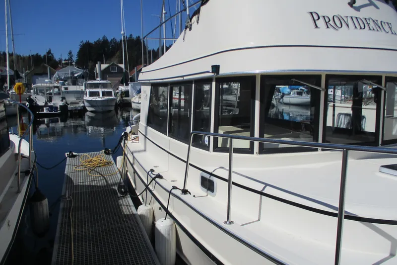Slide: The Image of 1997 Mainship 350 Trawler docked at marina, surrounded by other boats. - 4