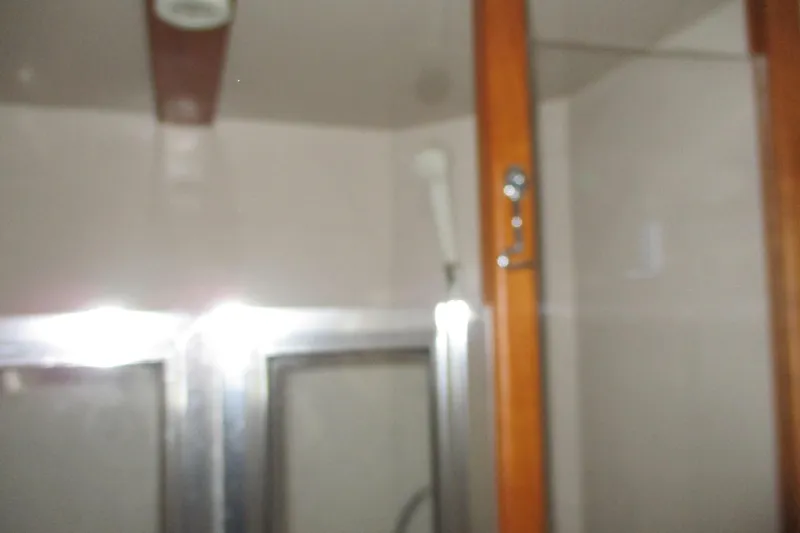 Slide: The Image of Interior of 1997 Mainship 350 Trawler bathroom with shower and wooden cabinet. - 41