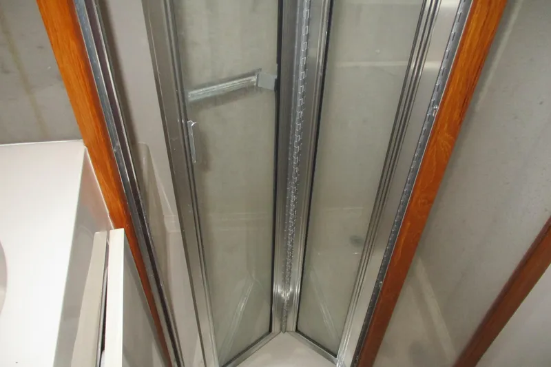 Slide: The Image of Shower area in 1997 Mainship 350 Trawler with glass doors and wooden trim. - 43