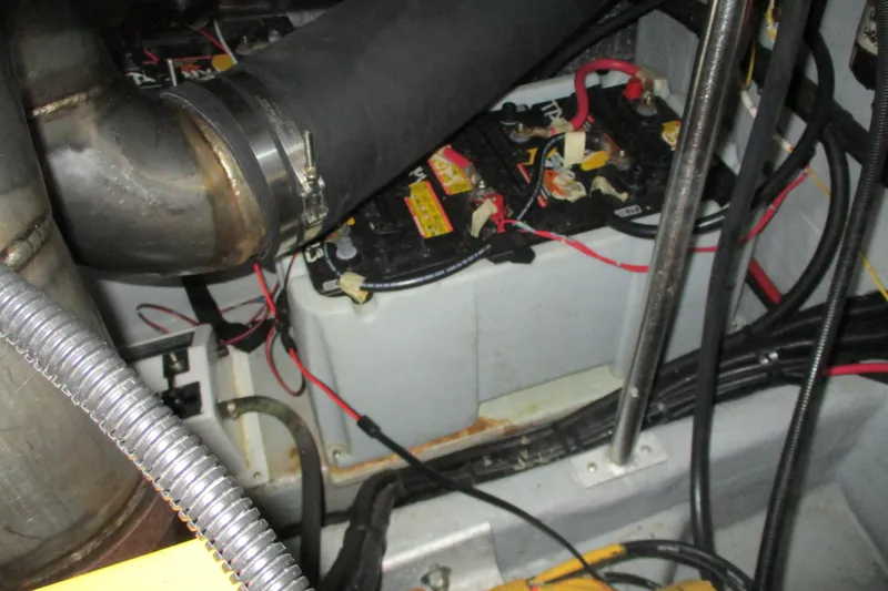 Slide: The Image of Engine compartment of a 1997 Mainship 350 Trawler with visible batteries and wiring. - 51