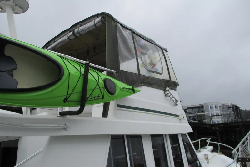 Slide: The Image of 1997 Mainship 350 Trawler with green kayak on deck, overcast sky. - 59