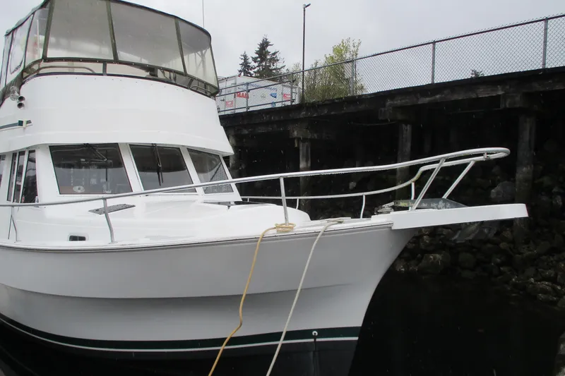 Slide: The Image of 1997 Mainship 350 Trawler docked, showcasing sleek white design and spacious upper deck. - 7