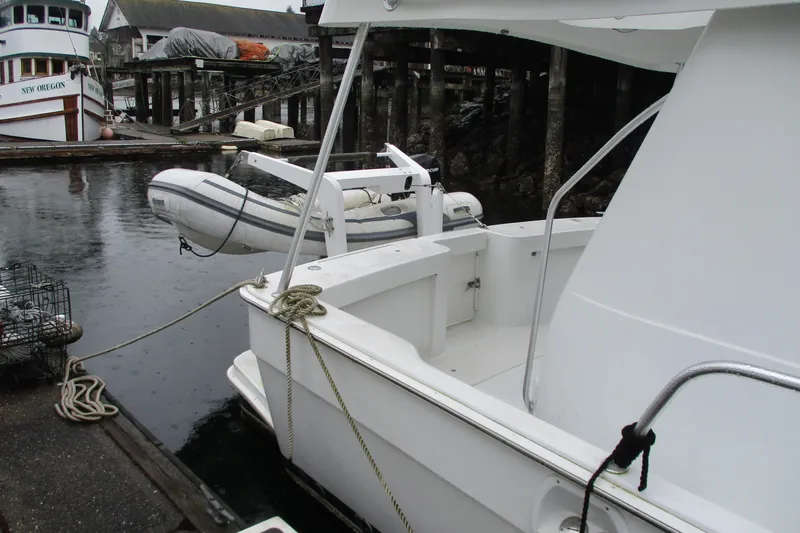 Slide: The Image of 1997 Mainship 350 Trawler docked, featuring a small inflatable boat and marina setting. - 10