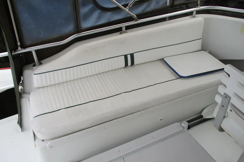 Slide: The Image of 1997 Mainship 350 Trawler interior with white cushioned seating and nautical decor. - 14