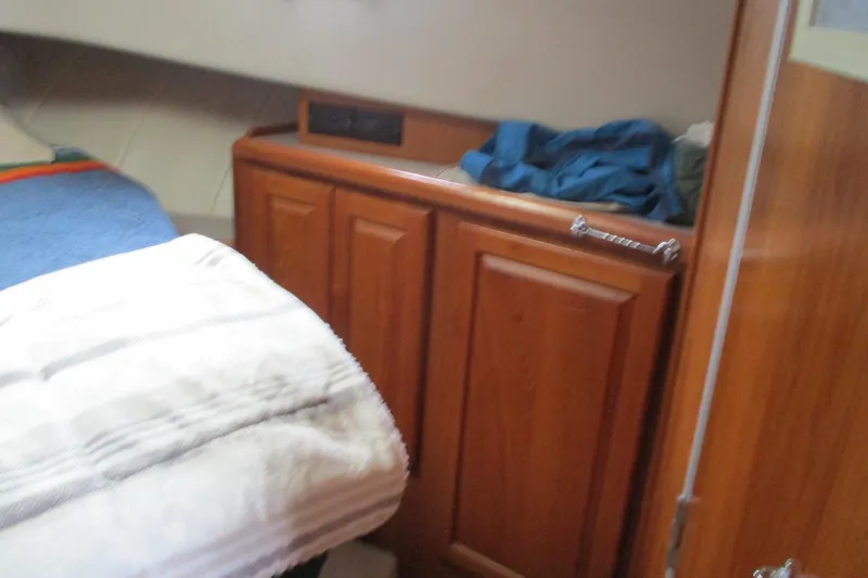 Slide: The Image of Interior cabin of 1997 Mainship 350 Trawler with wooden cabinetry and bedding. - 34