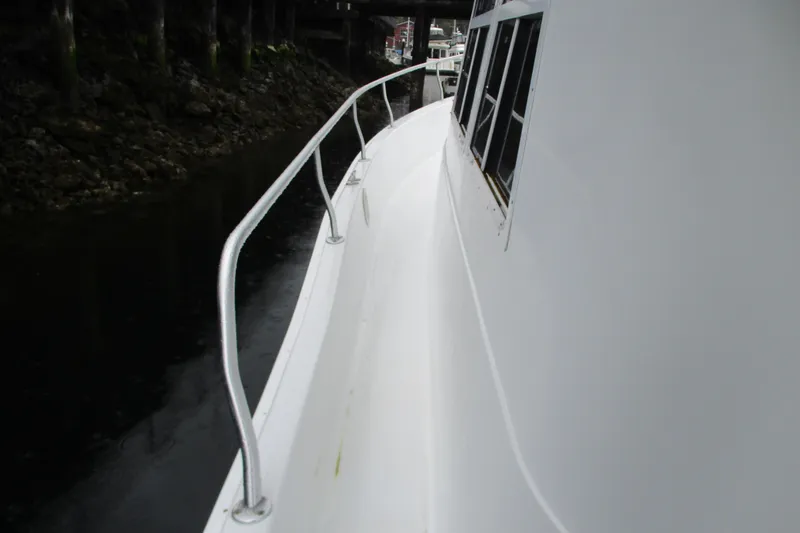 Slide: The Image of Side view of 1997 Mainship 350 Trawler boat with railing and windows. - 55