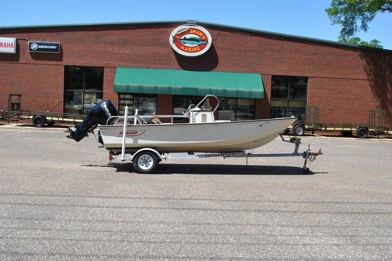 The Image of 1992 Boston Whaler 17 Montauk boat on trailer outside marine store. - 1