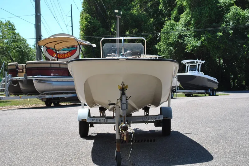 Slide: The Image of 1992 Boston Whaler 17 Montauk boat on trailer, parked outdoors with trees in background. - 11