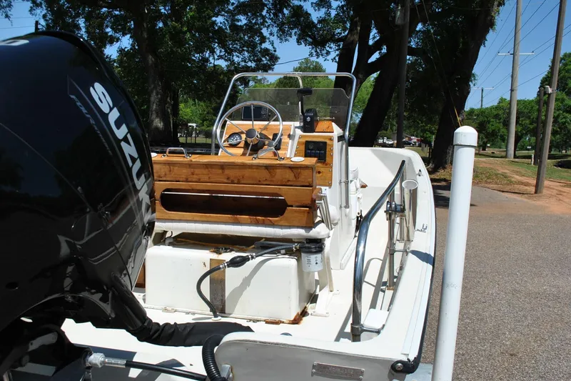 Slide: The Image of 1992 Boston Whaler 17 Montauk boat with Suzuki outboard motor, parked on a sunny day. - 13