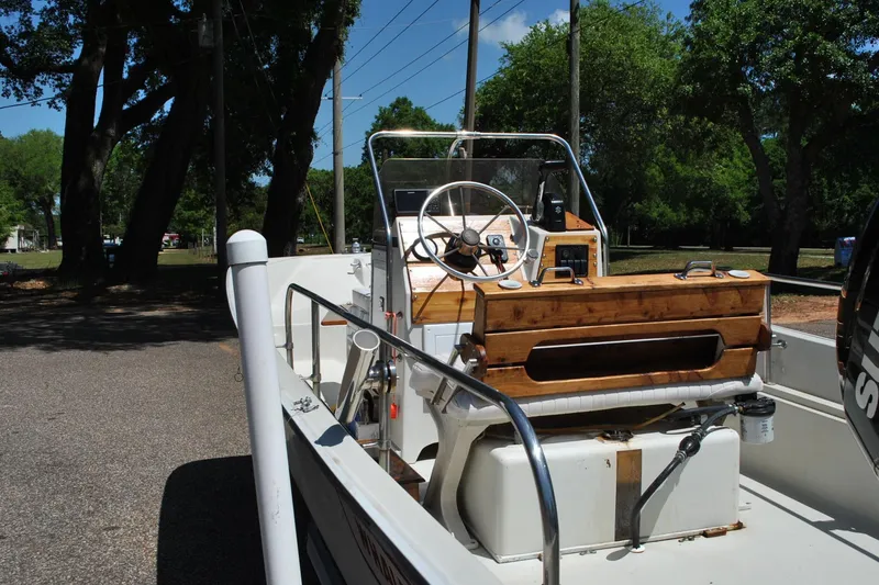 Slide: The Image of 1992 Boston Whaler 17 Montauk boat interior with steering wheel and wooden seating. - 14