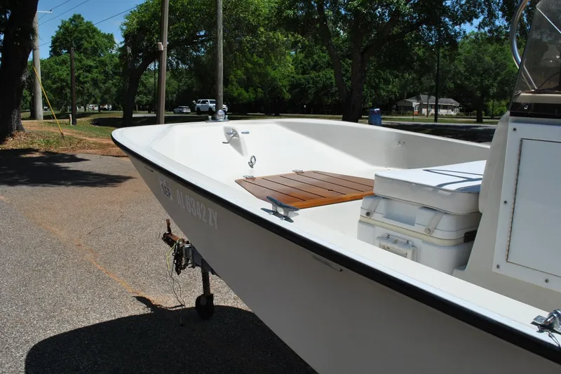 Slide: The Image of 1992 Boston Whaler 17 Montauk boat parked on a sunny street with trees in the background. - 15