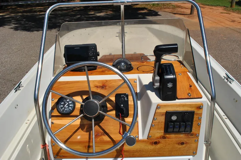 Slide: The Image of 1992 Boston Whaler 17 Montauk boat dashboard with steering wheel and controls. - 17