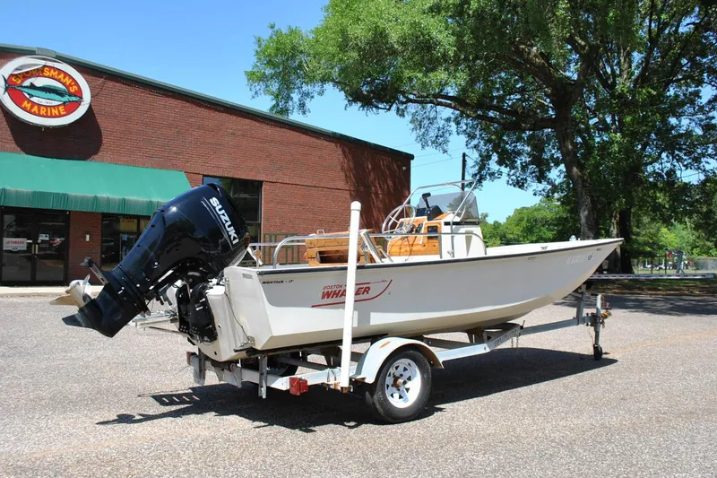 Slide: The Image of 1992 Boston Whaler 17 Montauk boat on trailer, parked outside marine store. - 3