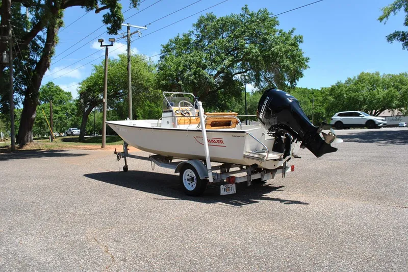Slide: The Image of 1992 Boston Whaler 17 Montauk boat on trailer in sunny parking lot. - 8