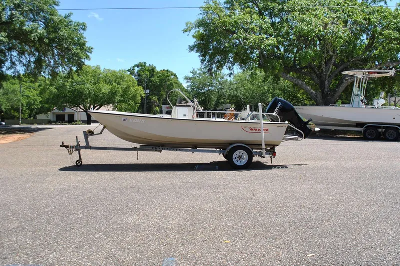 Slide: The Image of 1992 Boston Whaler 17 Montauk boat on trailer, parked outdoors under trees. - 9