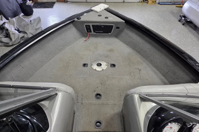 Slide: The Image of Interior view of a 2010 Tracker Targa V-18 WT boat, showing carpeted deck and storage compartments. - 6