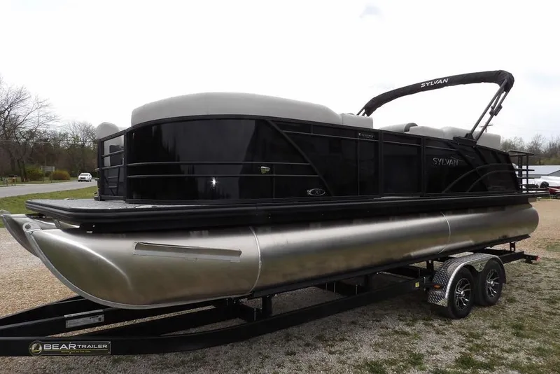Slide: The Image of 2026 Sylvan X5 CLZ pontoon boat on trailer, sleek black design, outdoor setting. - 9