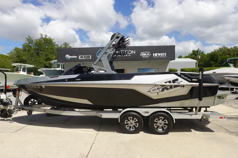 The Image of 2019 Axis T23 boat on trailer, parked outdoors under a partly cloudy sky. - 1