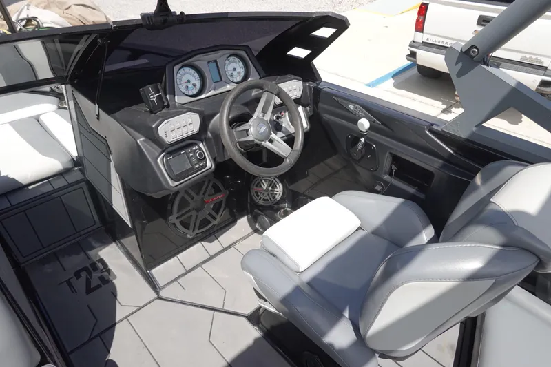 Slide: The Image of 2019 Axis T23 boat interior with steering wheel, gauges, and seating. - 10