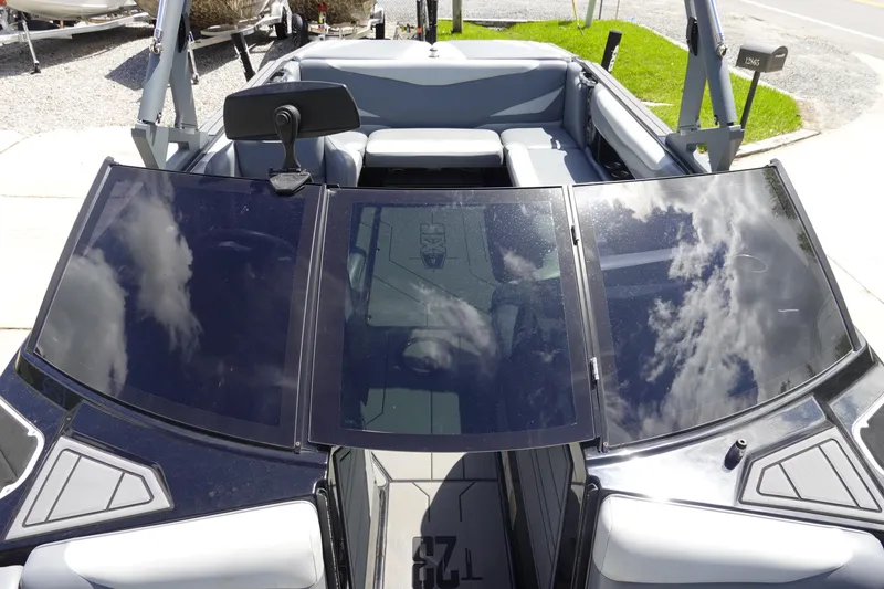 Slide: The Image of 2019 Axis T23 boat interior with sleek seating and reflective windshield under a cloudy sky. - 20