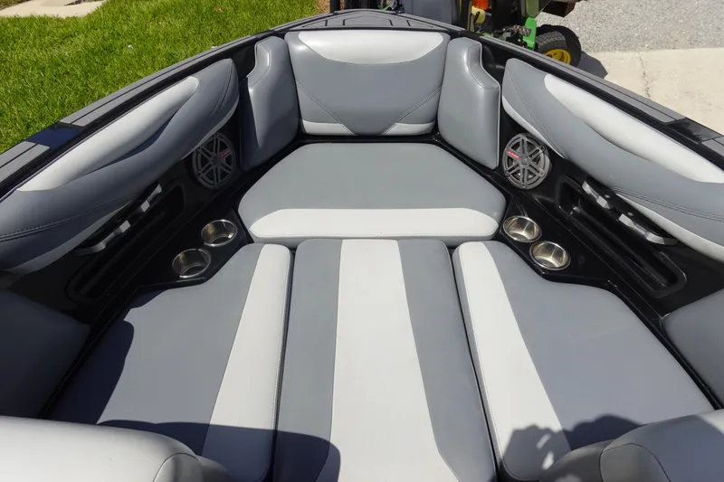 Slide: The Image of 2019 Axis T23 boat interior with gray seating, cup holders, and speakers. - 22