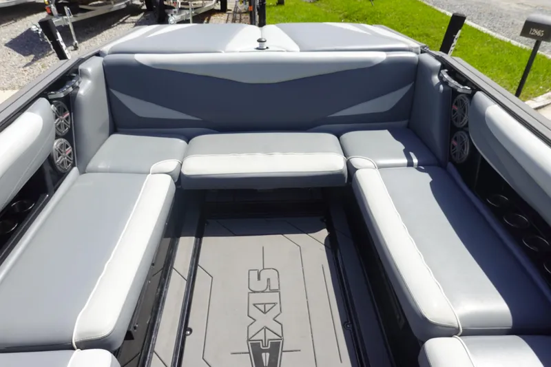 Slide: The Image of 2019 Axis T23 boat interior with gray seating and speakers, showcasing spacious design. - 9