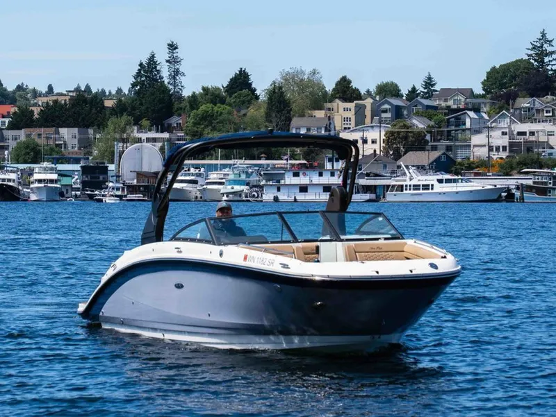 The Image of 2018 Sea Ray SDX 270 boat on calm water with cityscape background. - 1