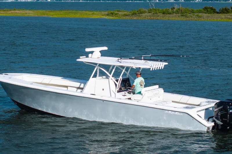 Slide: The Image of 2012 SeaHunter 37 Tournament boat cruising on a calm lake with a person at the helm. - 12