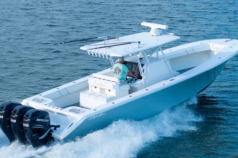 Slide: The Image of 2012 SeaHunter 37 Tournament boat cruising on open water with triple Mercury engines. - 14