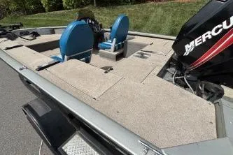 Slide: The Image of 2005 Tracker Tournament V-18 All Fish boat with Mercury engine, featuring blue seats and spacious deck. - 7