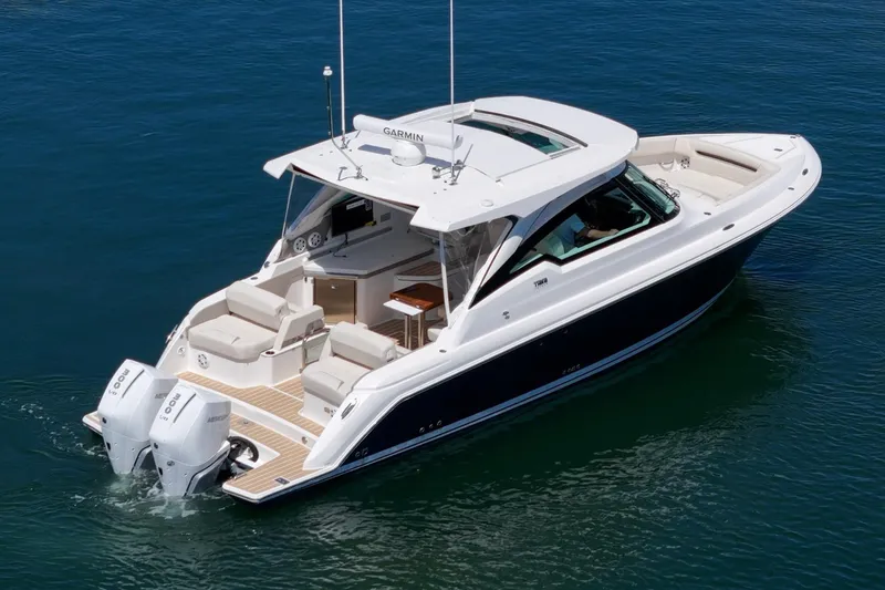 Slide: The Image of 2026 Tiara Yachts 34 LX cruising on clear blue water, showcasing luxury design and twin engines. - 13