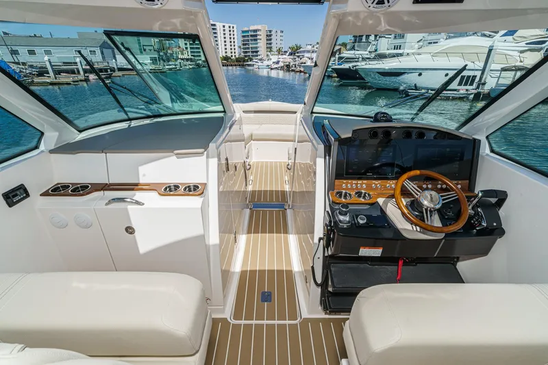 Slide: The Image of 2026 Tiara Yachts 34 LX helm with modern controls, docked in a marina. - 49