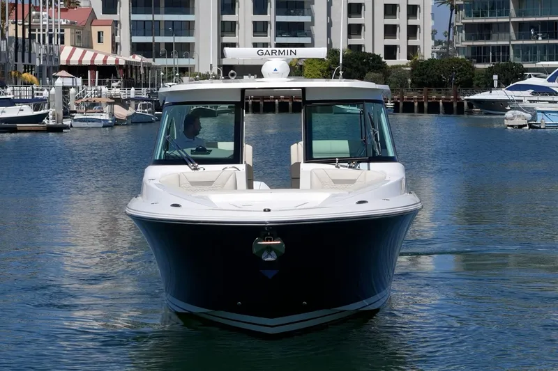 Slide: The Image of 2026 Tiara Yachts 34 LX cruising in a marina with modern buildings in the background. - 5