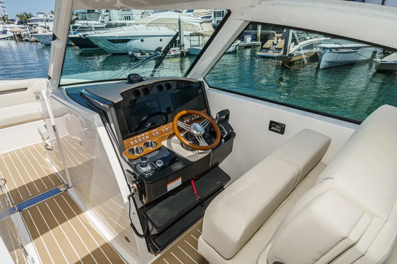 Slide: The Image of 2026 Tiara Yachts 34 LX helm with luxurious seating and modern controls at marina. - 51