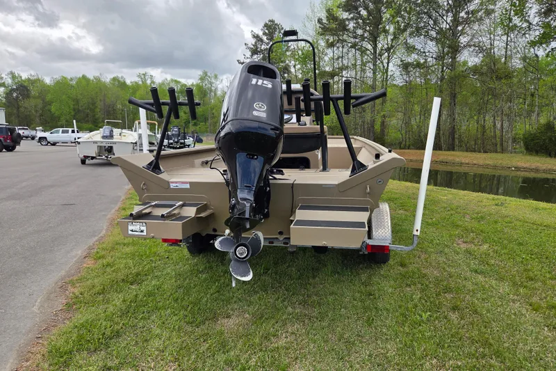 Slide: The Image of 2024 SeaArk 2072 FX boat with outboard motor on trailer, parked near a pond. - 3