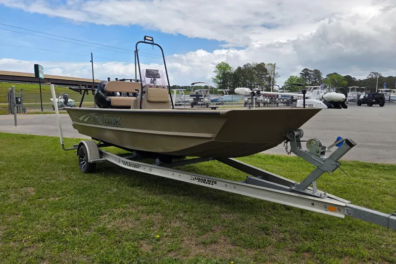 Slide: The Image of 2024 SeaArk 2072 FX boat on trailer, parked on grass under cloudy sky. - 6
