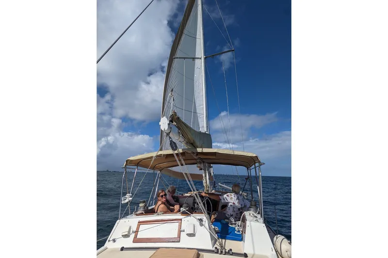Slide: The Image of Cozy dining setup inside a 1973 CAL 2-46 sailboat, featuring elegant tableware and nautical decor. - 4