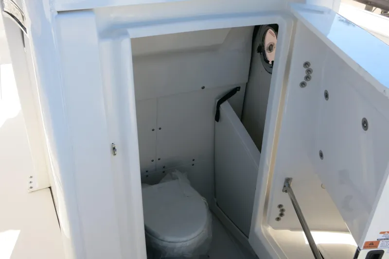 Slide: The Image of 2026 Robalo R250 Center Console boat interior with compact marine toilet. - 21