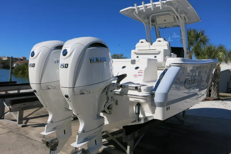 Slide: The Image of 2026 Robalo R250 Center Console boat with twin Yamaha 150 engines, docked outdoors. - 3