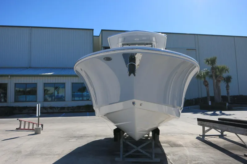 Slide: The Image of 2026 Robalo R250 Center Console boat displayed outdoors near a warehouse. - 7