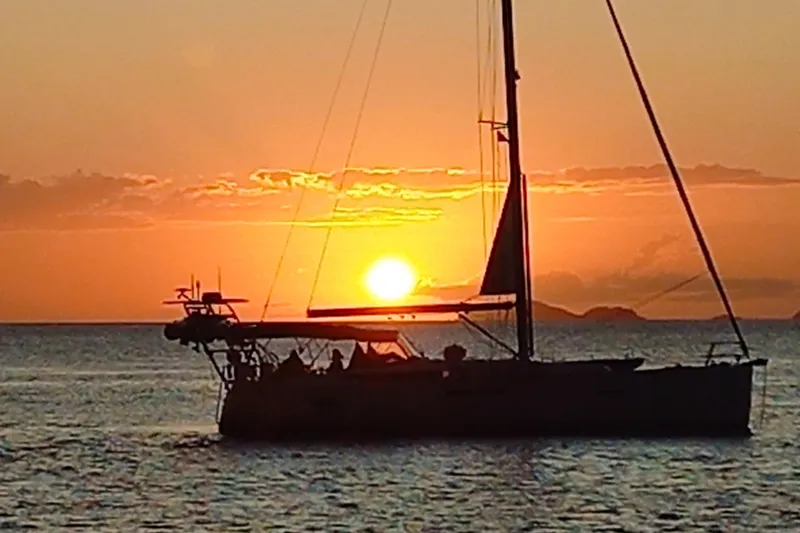 The Image of Sailing yacht Jeanneau Sun Odyssey 469 at sunset, 2015 model, silhouetted against the ocean horizon. - 0