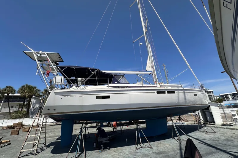 Slide: The Image of 2015 Jeanneau Sun Odyssey 469 sailboat on dry dock under clear blue sky. - 35