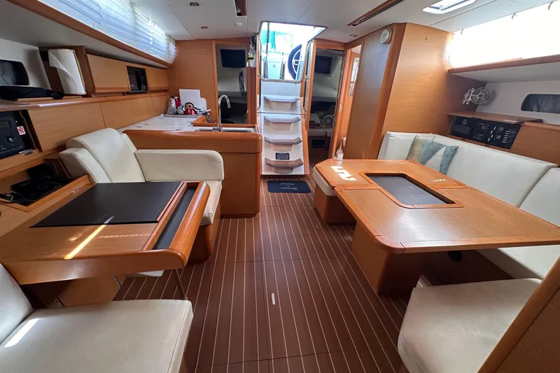 Slide: The Image of Interior of 2015 Jeanneau Sun Odyssey 469 yacht with modern wood finish and seating area. - 4