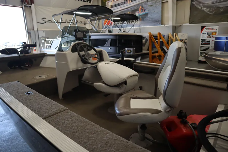 Slide: The Image of 2013 MirroCraft 1416 Troller boat interior with steering wheel and seating in showroom. - 8