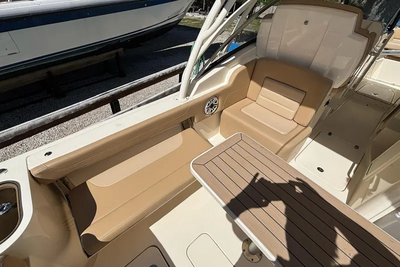 Slide: The Image of 2024 Scout 255 Dorado boat interior with tan seating and wooden table. - 11
