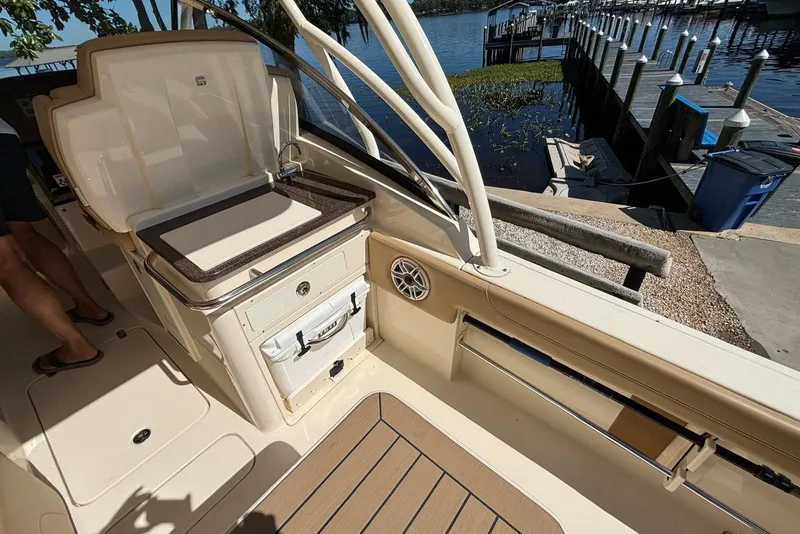Slide: The Image of 2024 Scout 255 Dorado boat interior with sink and storage, dockside view. - 19