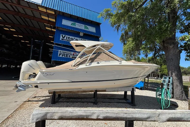 Slide: The Image of 2024 Scout 255 Dorado boat displayed outdoors near a storage facility. - 2