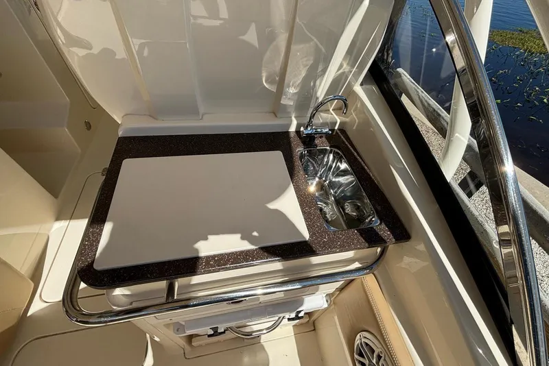 Slide: The Image of 2024 Scout 255 Dorado boat interior with sink and cutting board. - 20