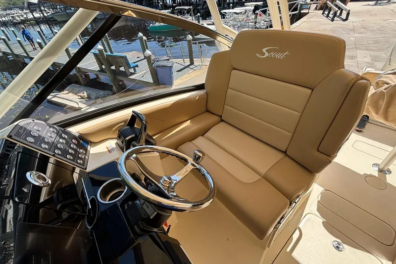 Slide: The Image of 2024 Scout 255 Dorado boat helm with tan leather seating and modern controls. - 23