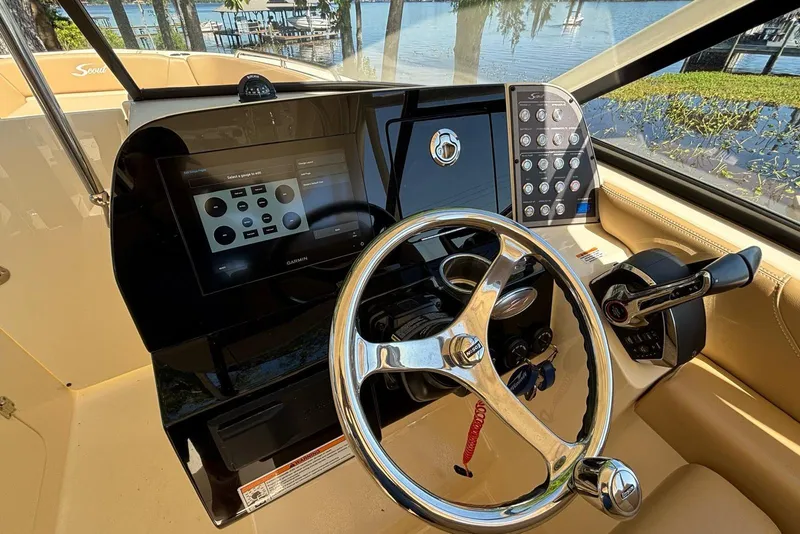 Slide: The Image of 2024 Scout 255 Dorado boat dashboard with steering wheel and control panel. - 25